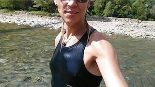 Nadando no mountain river com roupas - tênis, shorts e camiseta