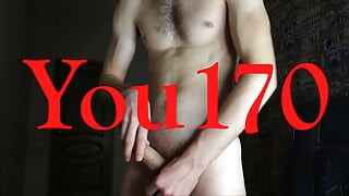 The guy jerks off his big dick while standing and moans