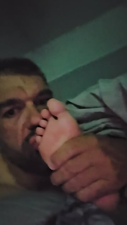 Îi suge degetele de la picioare în timp ce urmărește un film