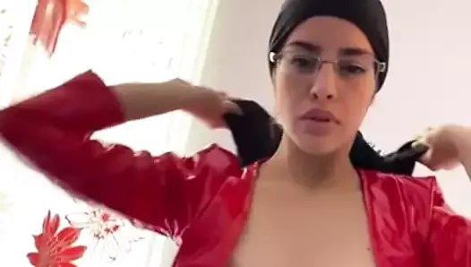 sexy Arab in leather dress doing sensual dance with her hijab on