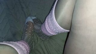 Pies de chico mariquita en lindos calcetines de nylon blancos sobre medias de nylon