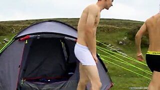 Zwei heterosexuelle Freunde spielen auf dem Campingplatz mit ihren Schwänzen