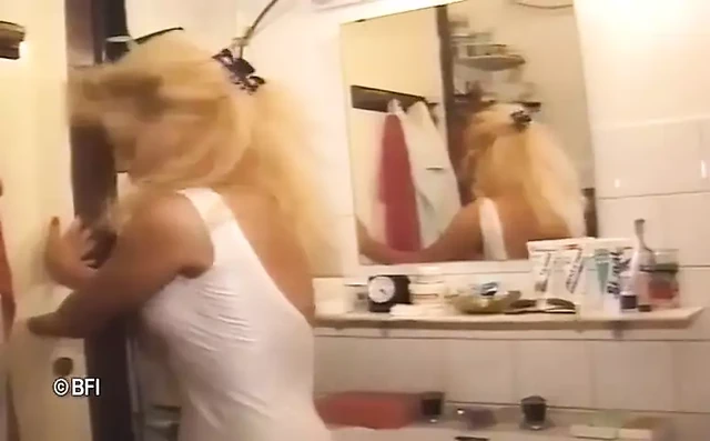 Blonde pissing on her friend in the bathroom
