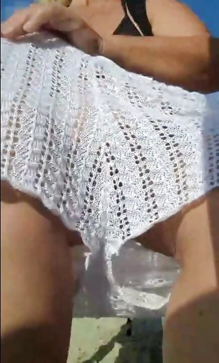 Hot crown sunbathing on the beach in transparent micro bikini