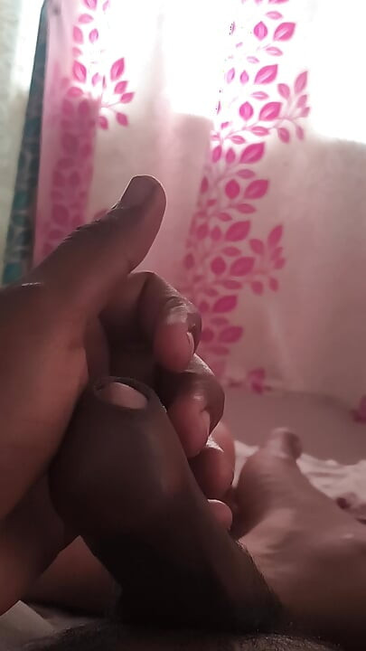 A man experiences pleasure by masturbating his penis with his hand and massaging it with coconut oil.