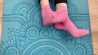 Fitness-mädchen macht Übungen auf der matte in socken und gibt ihrem trainer einen footjob mit sperma auf ihren füßen
