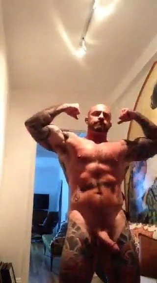 Inked muscular dilf flexes with his big cock out