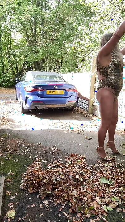Seksi transvestit kellycd2022 u zlatnom kupaćem kostimu i štiklama čisti lišće