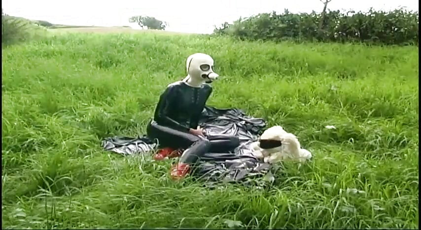 Σκλάβα φετίχ με λάτεξ περπατά και ρουφάει ένα δονητή στο γρασίδι