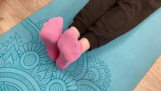 Fitness-mädchen macht Übungen auf der matte in socken und gibt ihrem trainer einen footjob mit sperma auf ihren füßen