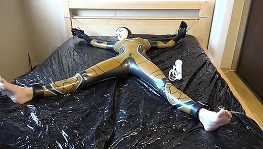Latex Danielle is attached to the bed and masturbated with the massage vibrator