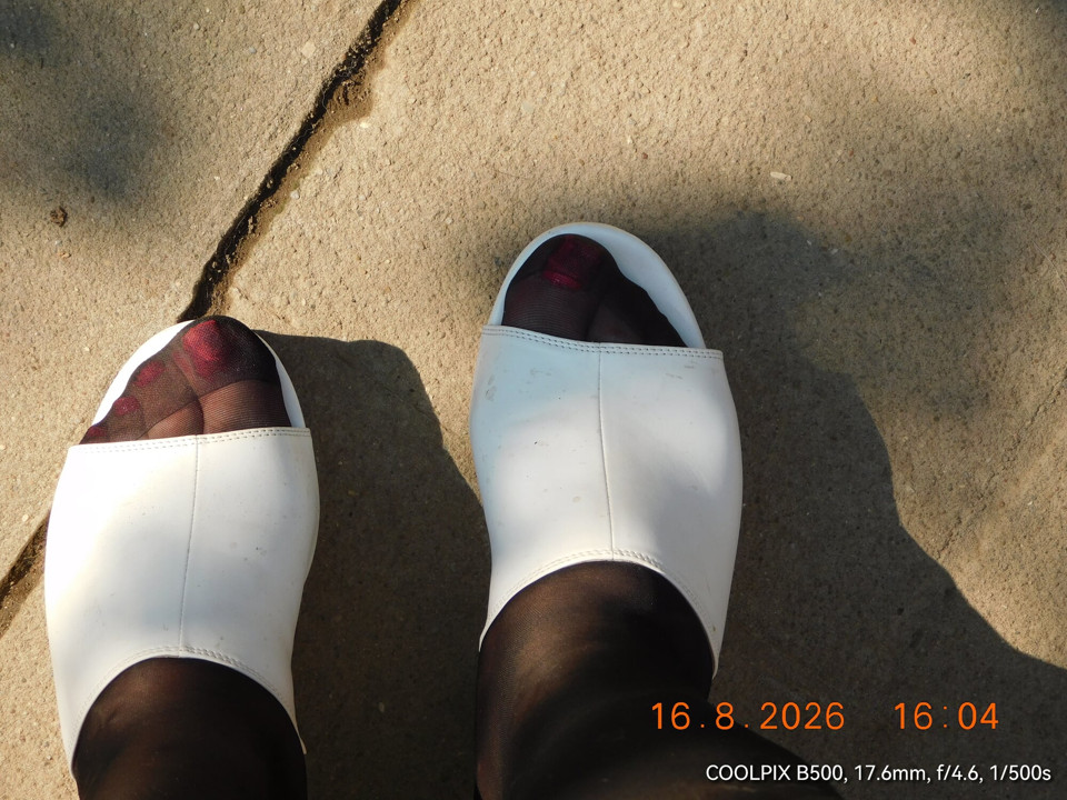 White mules and brown tights in the garden