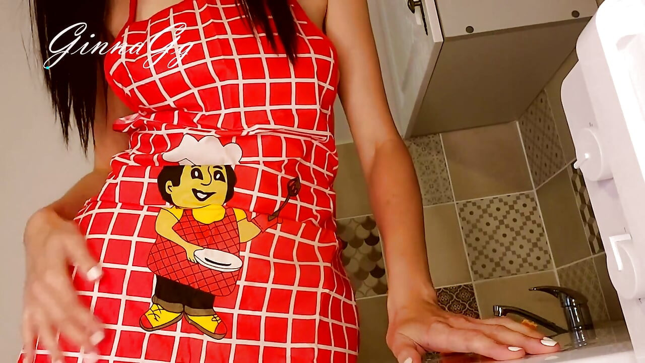 热辣的家庭主妇在厨房里性地撸着她的围裙