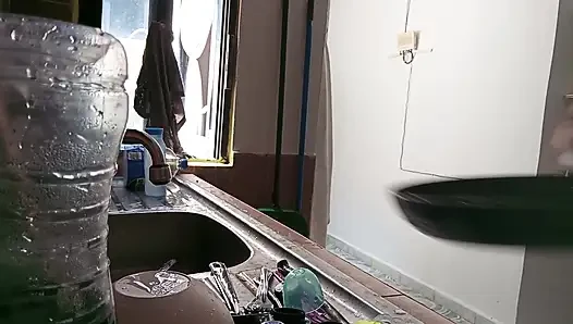 Mother-in-law cleans in the kitchen in bra