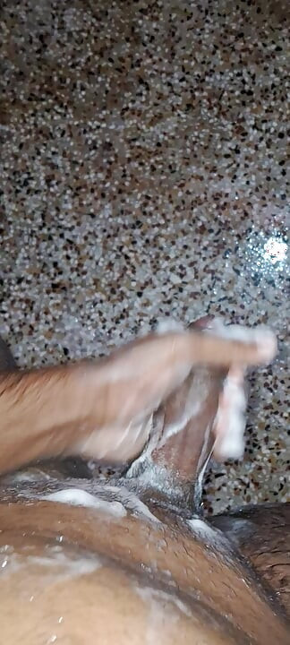 Um jovem garoto hindu da Índia está fodendo seu pau grosso com as mãos enquanto toma banho