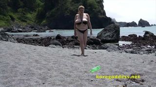 Vrouw met grote tieten op het strand masturbeert
