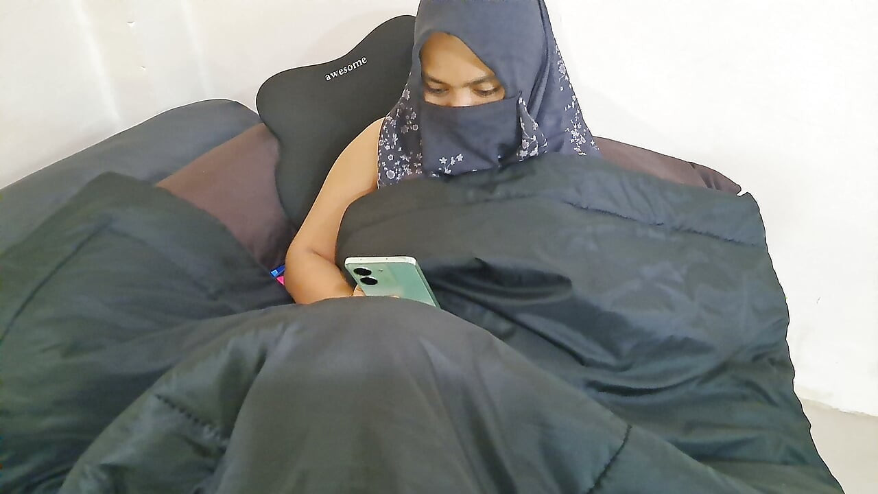 A woman in a hijab is masturbating on the sly.