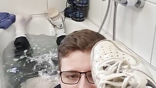Divertimento nella vasca da bagno con le scarpe da ginnastica