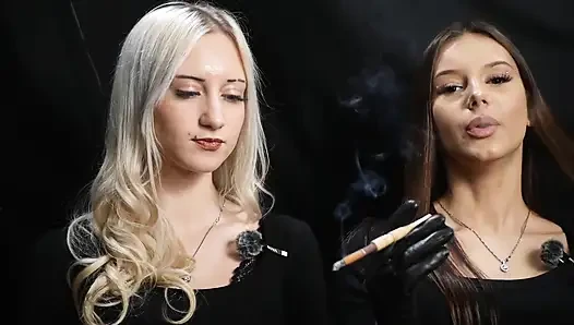 Dua wanita berpakaian hitam berbagi rokok dengan asap perlahan dan interaksi yang menyenangkan