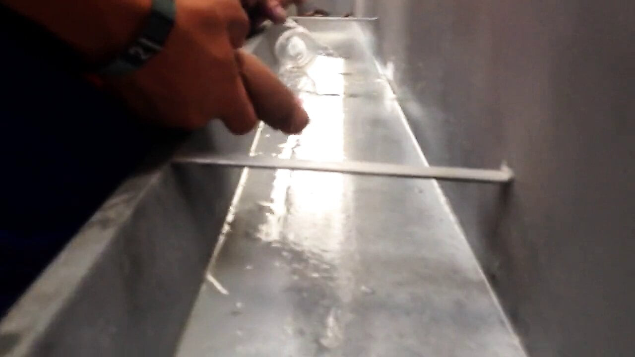 Une longue bite non coupée pisse en public à l'urinoir