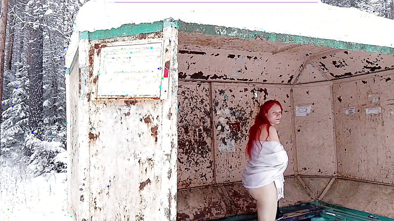 A redheaded girl is playing with her body at a public bus stop in winter!