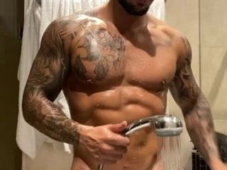 Garanhão muscular tatuado lavando seu pau enorme