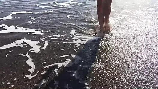 Yalnız gür Rus bebek deniz kıyısındaki kayada amını oyuncak yapıyor