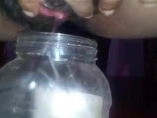 Menina do Sri Lanka mijando em uma garrafa
