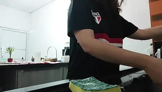 Woman teasing while washing dishes. She loves to transmit to the voyeurs on duty