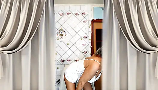 Real home solo of a mature woman in a small cozy kitchen.