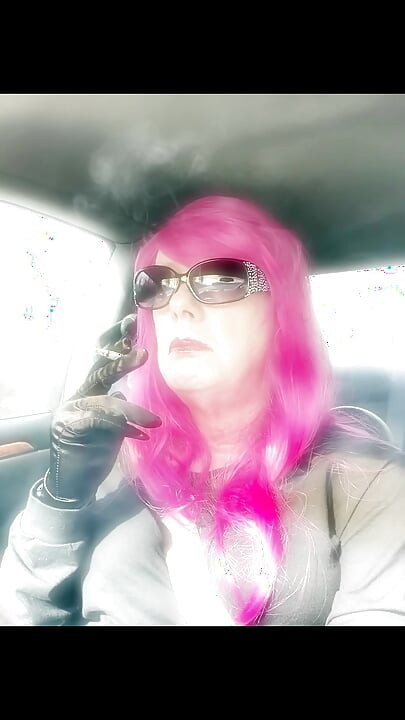 Pembe saçlı ve deri eldivenli Bayan Roman TG sigara içiyor vs120s mentol sürüş cd olgun ladyboy