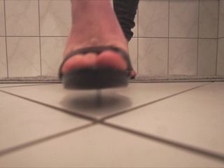 Berjalan di atas tumit sandal hitam di kamar mandi dengan footjob