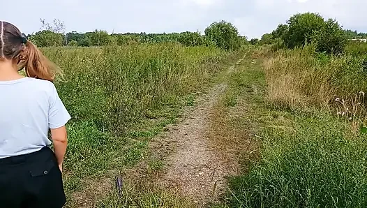 Bottomless girl with pigtails walks along a country road