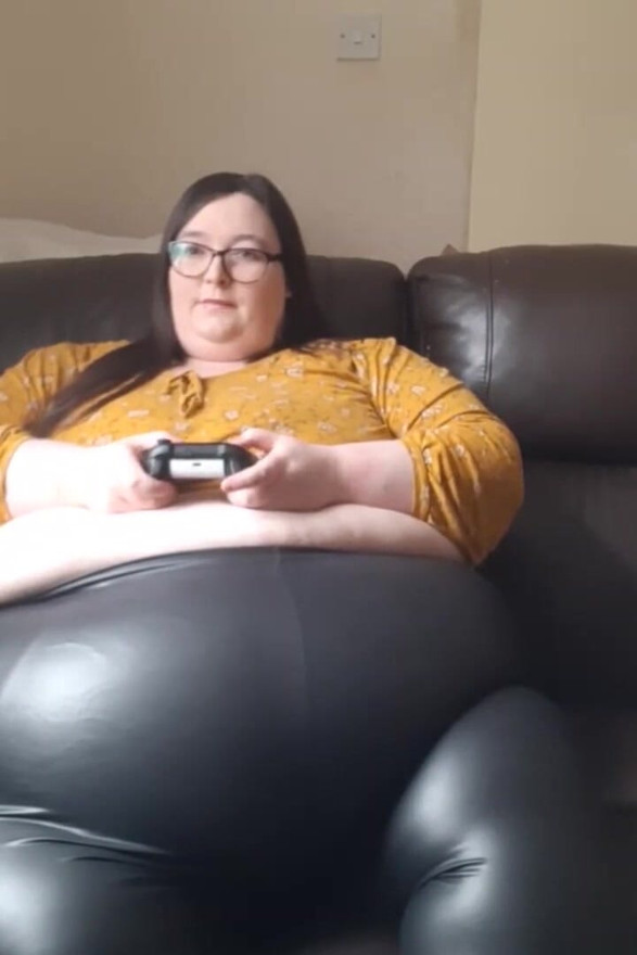 Fată jucătoare SSBBW în pantaloni de piele pe burtă