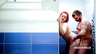Rossa bella donna scopa sotto la doccia