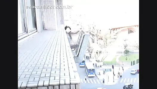 Brunette masturbates with big black toy on apartment's balcony