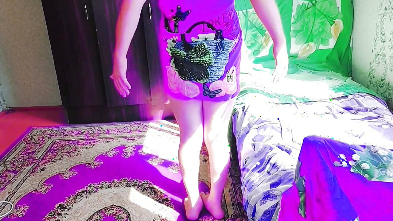 Playful sissy sitting cross-legged on fluffy pink carpet