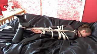 Catsuit im Hogtie und geknebelt