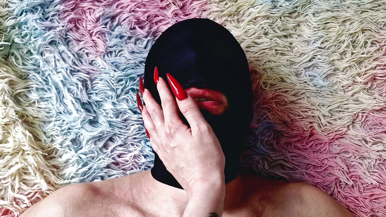 Passionate, arousing French kissing. The mistress dominantly kisses the masked submissive and smears her red lipstick all over h