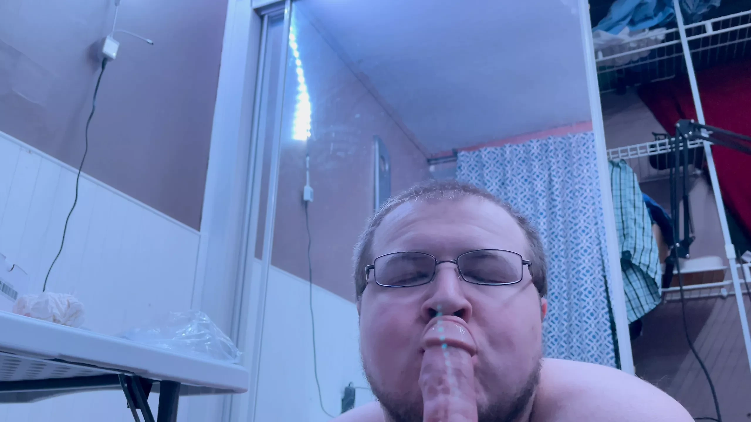 Chubby gay guy practices oral on big black dildo