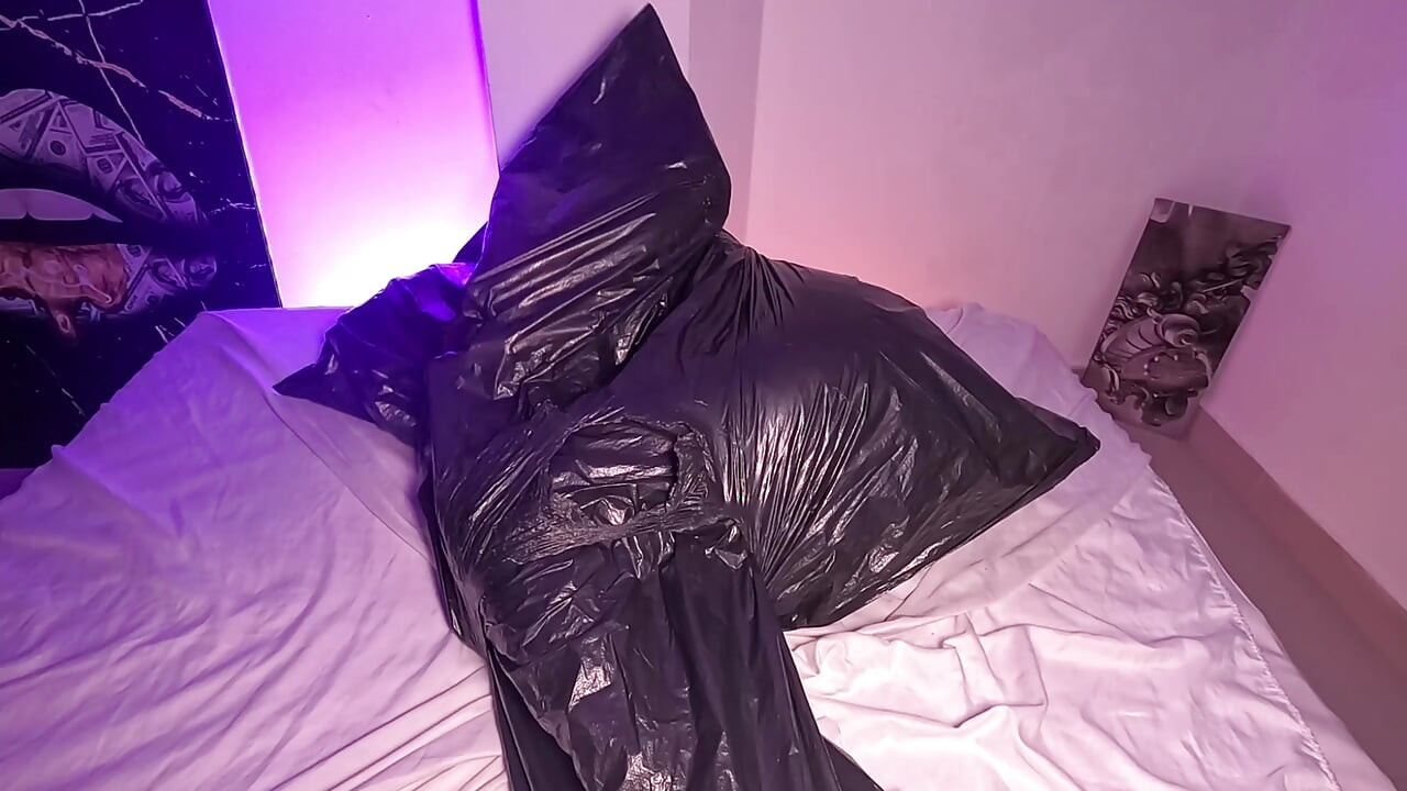 Jente i søppelsekk leker med pusten