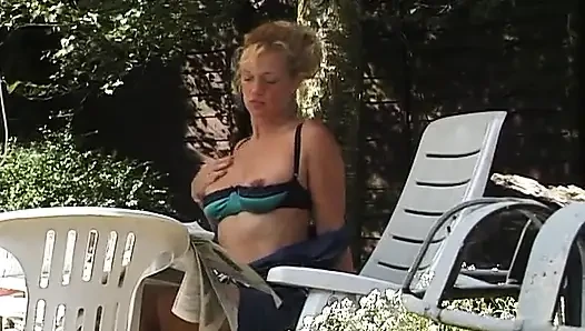 Sarışın orta yaşlı seksi kadın açık havada göğüslerini gösteriyor