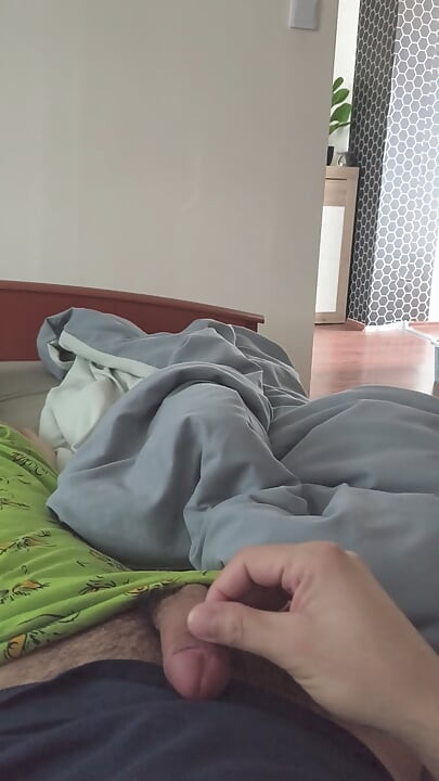 Cute handjob on the bed with a hard and erect penis