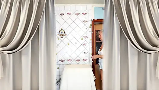 Real home solo of a mature woman in a small cozy kitchen.