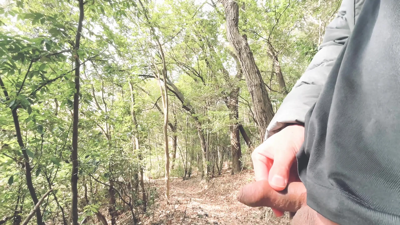 A boy with a small foreskin pees a huge stream outdoors