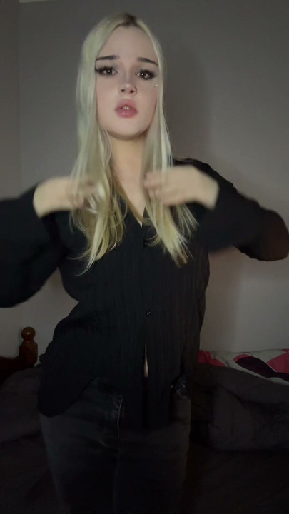 Chica trans blanca en un traje de rejilla negro se burla de su polla