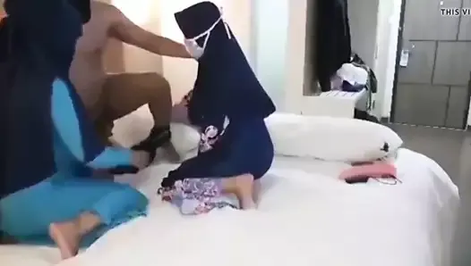 Trójkąt z dwiema kobietami w hidżabie