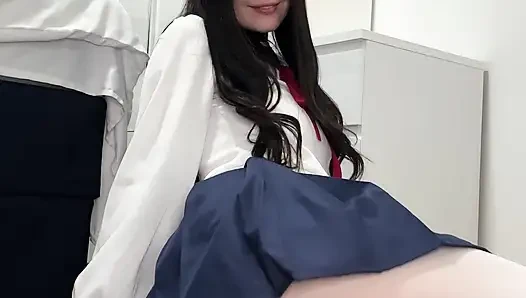 Sexy schwarzhaariger teenager in japanischer schuluniform zieht sich auf dem boden aus