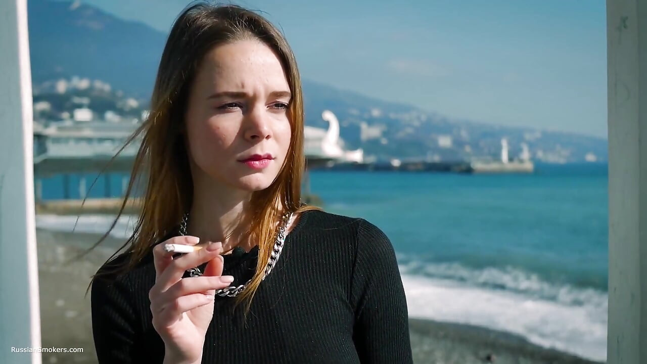 Jong Russisch meisje dat sigaret rookt aan zee