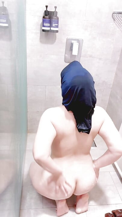 Une Indonésienne prend une douche dans des vêtements traditionnels